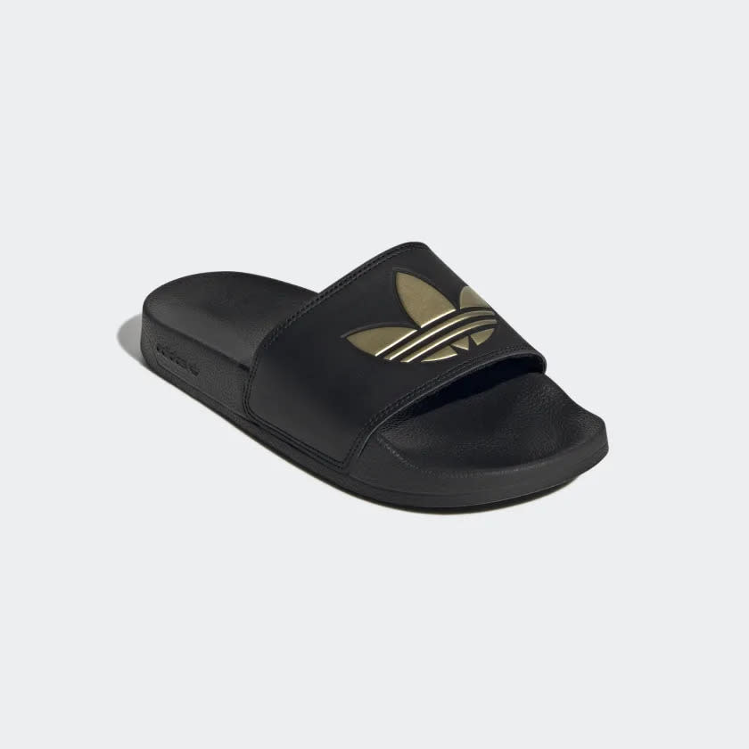 Black slide with gold Adidas logo on front.