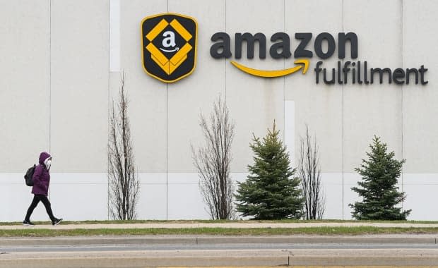 A person walks outside the Amazon fulfilment centre in Brampton, Ont., on April 20. In a statement to CBC News on Saturday, Amazon said three shifts at its Brampton facility and one shift at its centre in Bolton, Ont., are being temporarily suspended due to COVID-19 outbreaks.