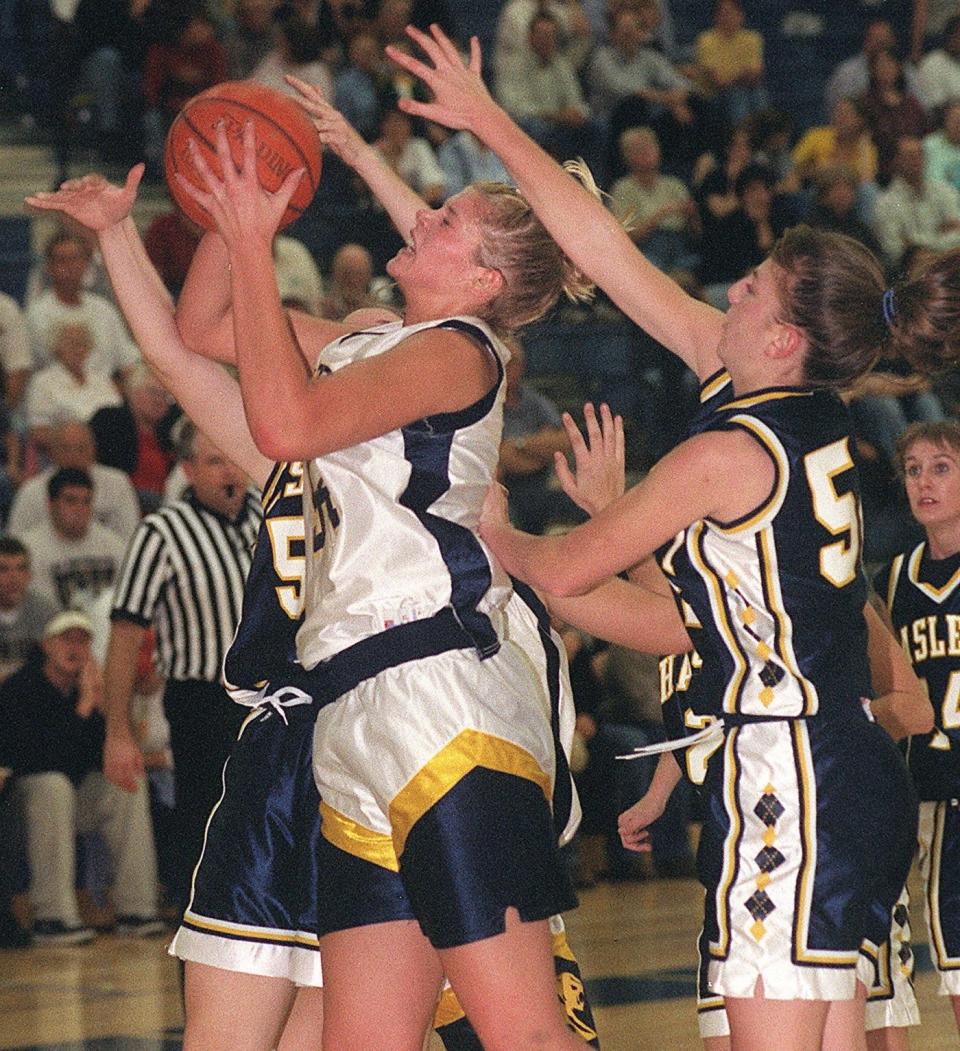 DeWitt's Jennifer Smith center, grabs a rebound between Haslett defenders Kacie Wilson, left, and Maria Sciarini, right, during a 1999 contest. Smith is part of the Greater Lansing Sports Hall of Fame's 2023 class.