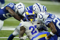 Los Angeles Rams' Darrell Henderson (27) is tackled by Indianapolis Colts' Bobby Okereke (58), Al-Quadin Muhammad (97) and Kenny Moore II (23) during the first half of an NFL football game, Sunday, Sept. 19, 2021, in Indianapolis. (AP Photo/Michael Conroy)