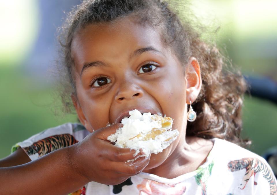 Jaylyn Estinable, 6, of West Allis eats a cream puff while with her mother, Jennifer Harder (not pictured) at the Wisconsin State Fair in West Allis on Thursday, Aug. 1, 2019.