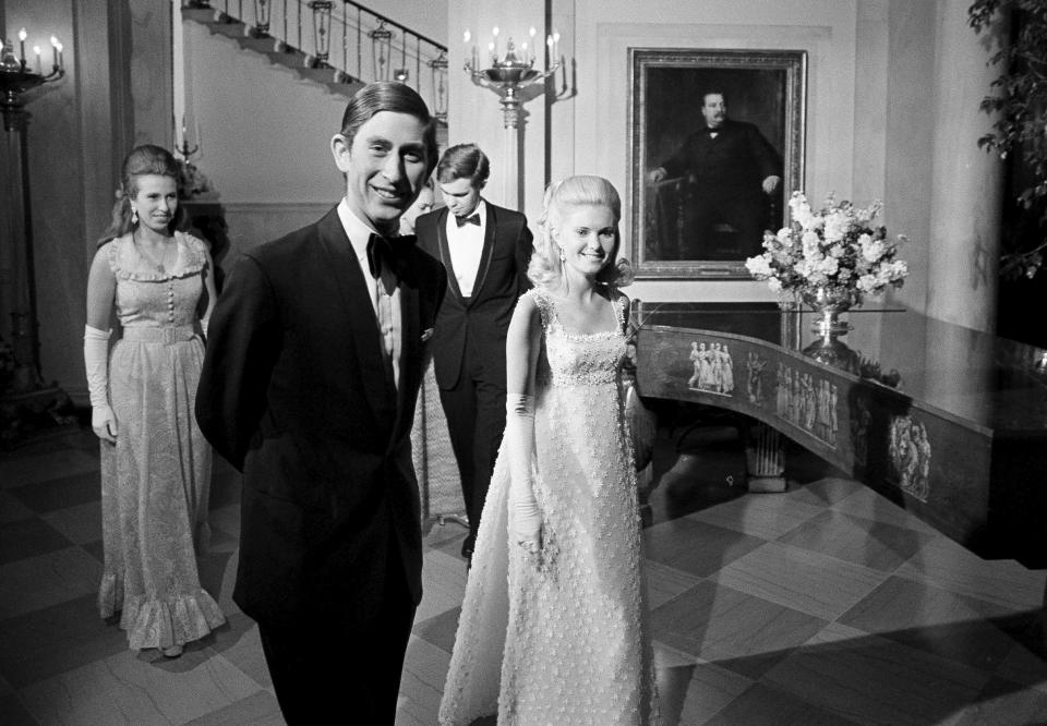 FILE - Prince Charles and Tricia Nixon, daughter of President Richard Nixon, lead the way to join guests at a White House formal supper-dance, July 17, 1970. Following are Princess Anne, left, and Julie, hidden, and Daivd Eisenhower. (AP Photo/RH, File)