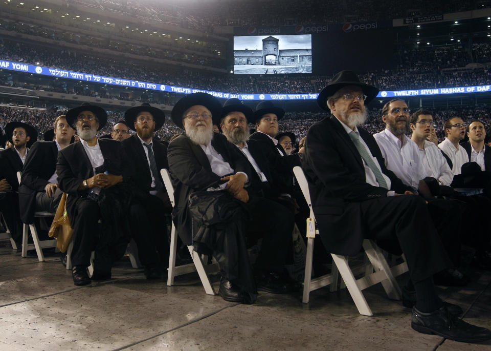 Orthodox Jewish men watch a video on large screens at MetLife stadium in East Rutherford, N.J, Wednesday, Aug. 1, 2012, during the celebration Siyum HaShas. The Siyum HaShas, marks the completion of the Daf Yomi, or daily reading and study of one page of the 2,711 page book. The cycle takes about 7½ years to finish.This is the 12th put on my Agudath Israel of America, an Orthodox Jewish organization based in New York. Organizers say this year's will be, by far, the largest one yet. More than 90,000 tickets have been sold, and faithful will gather at about 100 locations worldwide to watch the celebration. (AP Photo/Mel Evans)