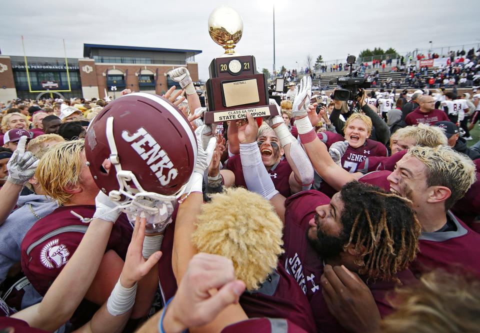 Jenks celebrates with their Class 6A-I trophy after defeating Tulsa Union on Saturday in Edmond.