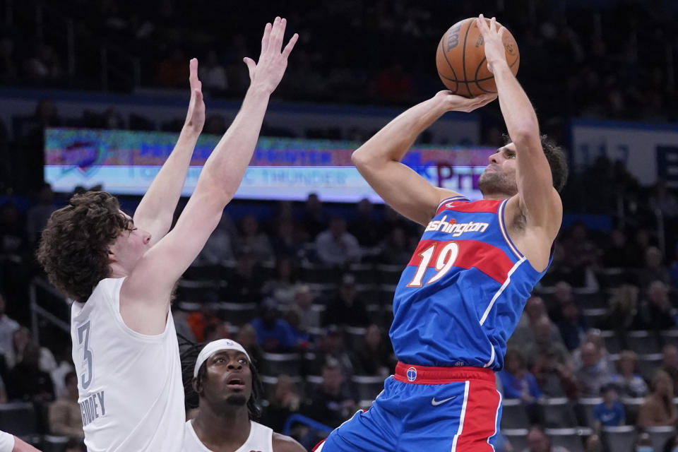 Washington Wizards guard Raul Neto (19) shoots in front of Oklahoma City Thunder guard Josh Giddey (3) and forward Luguentz Dort, center, in the first half of an NBA basketball game Friday, Nov. 26, 2021, in Oklahoma City. (AP Photo/Sue Ogrocki)