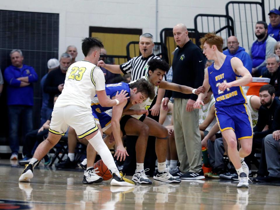 Tri-Valley's Max Lyall, left, and Terrell Darden fight with West Muskingum's Jack Porter for a loose ball on Tuesday night in Dresden. Tri-Valley held on for a 49-46 win to stay one game back of Maysville in the Muskingum Valley League-Big School Division standings with three games remaining.