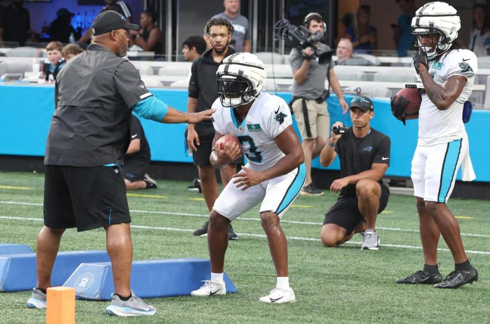 Carolina Panthers running back Raheem Blackshear, center, receives instructions during the team’s Fan Fest practice at Bank of America Stadium on Wednesday, August 2, 2023.