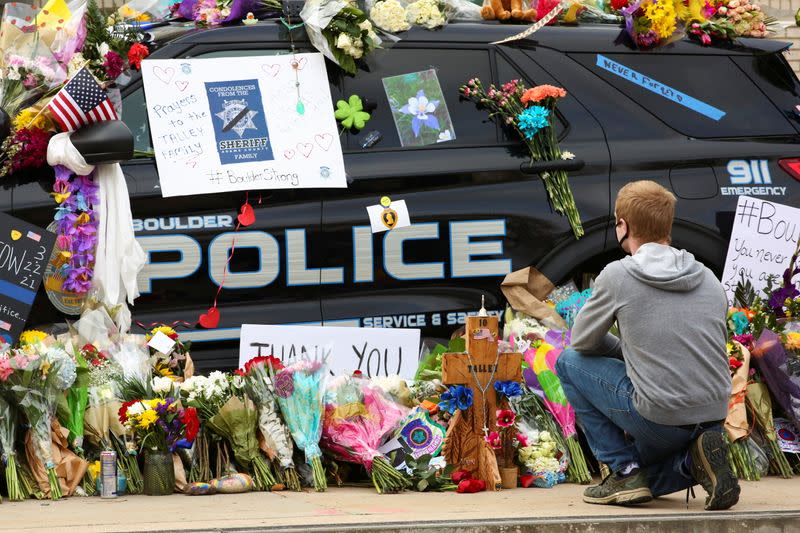 People attend a candlelight vigil at a park near the site of a mass shooting at a King Soopers grocery store in Boulder