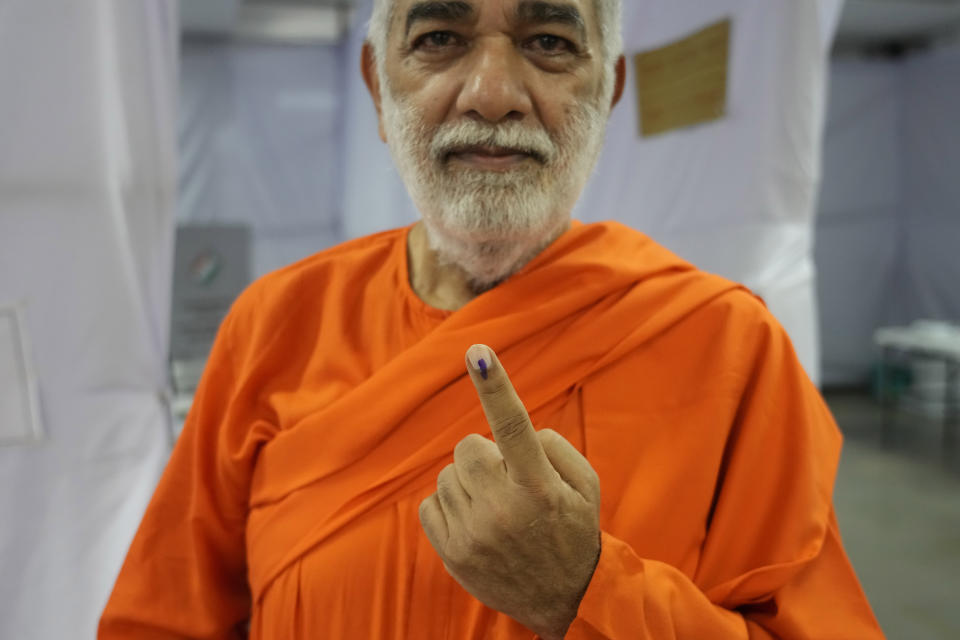 A man in saffron robes shows the indelible ink mark on his index finger after casting vote at a polling station during the fifth round of multi-phase national elections in Mumbai, India, Monday, May 20, 2024. (AP Photo/Rafiq Maqbool)