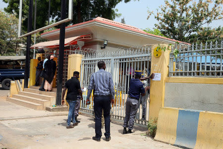 A local security staff member places a notice on the wall after anti-South African protesters attacked the MTN office in Abuja, Nigeria February 23, 2017. REUTERS/Afolabi Sotunde