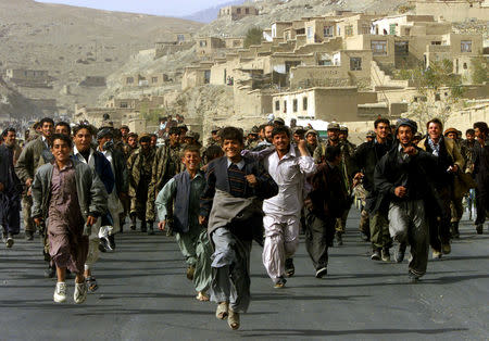 FILE PHOTO: Residents of Kabul celebrate and escort Northern Alliance fighters entering the Afghan capital Kabul, November 13, 2001. Forces of the anti-Taliban Northern Alliance entered Kabul as reports from across the country pointed to a collapse of Taliban rule. Civilians greeted opposition fighters and celebrated in the streets of Kabul. REUTERS/Yannis Behrakis/File photo
