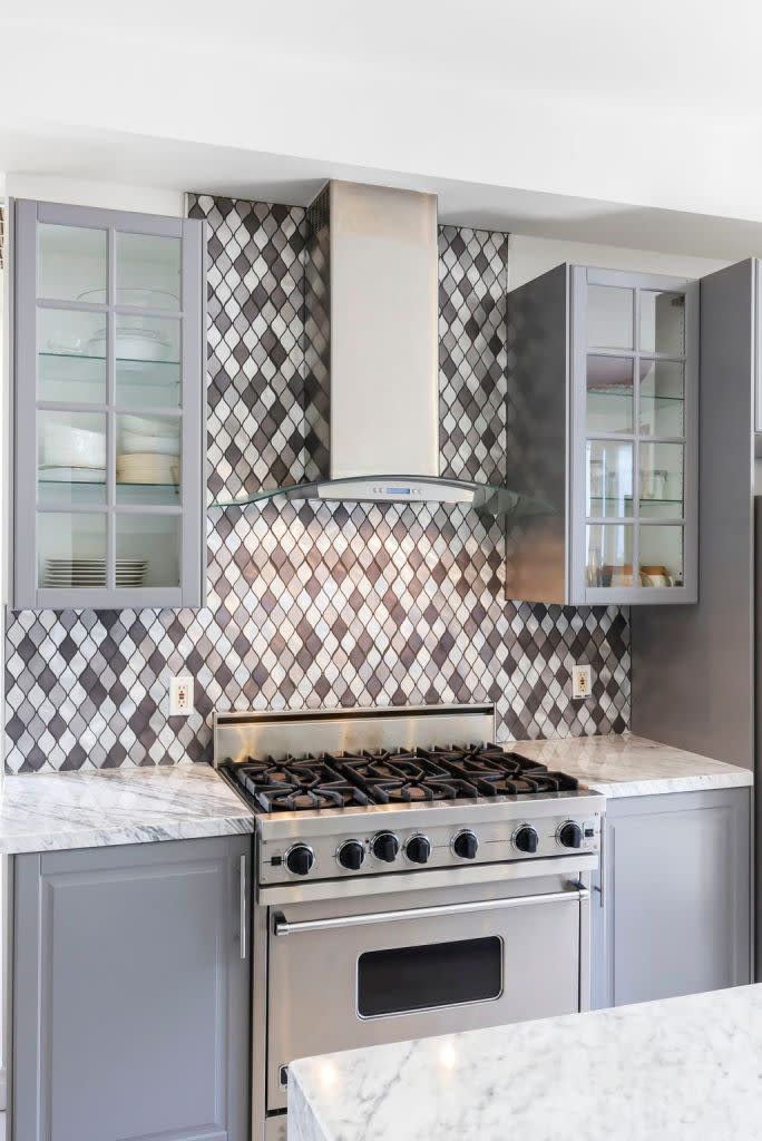 The kitchen features a chic backsplash along with plenty of storage. Rews Media