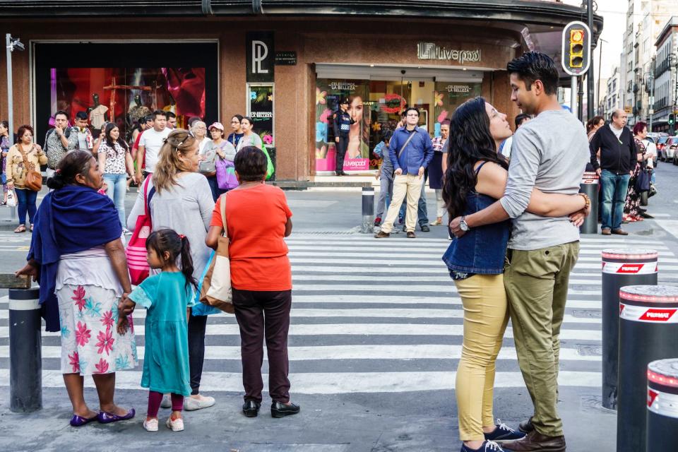 A young couple hugging next to a busy intersection in Mexico.