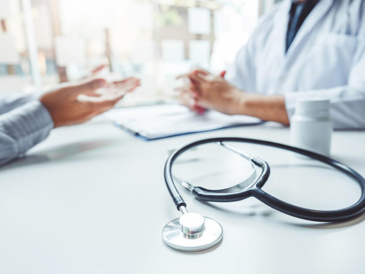 Doctors and patients consulting and diagnostic examining sit and talk. At the table near the window in the hospital medicine concept