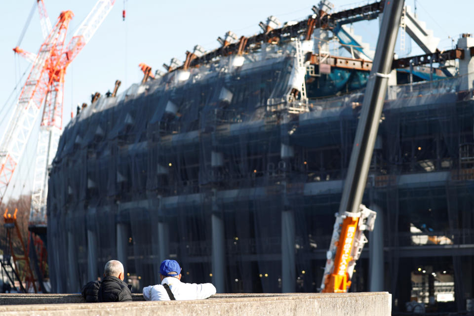 Men looks at the construction site of the New National Stadium, main stadium of Tokyo 2020 (REUTERS)