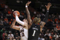 Oregon State's Roman Silva (12) tries to shoot around Washington's Nate Roberts (1) during the first half of an NCAA college basketball game Thursday, Jan. 20, 2022, in Corvallis, Ore. (AP Photo/Amanda Loman)