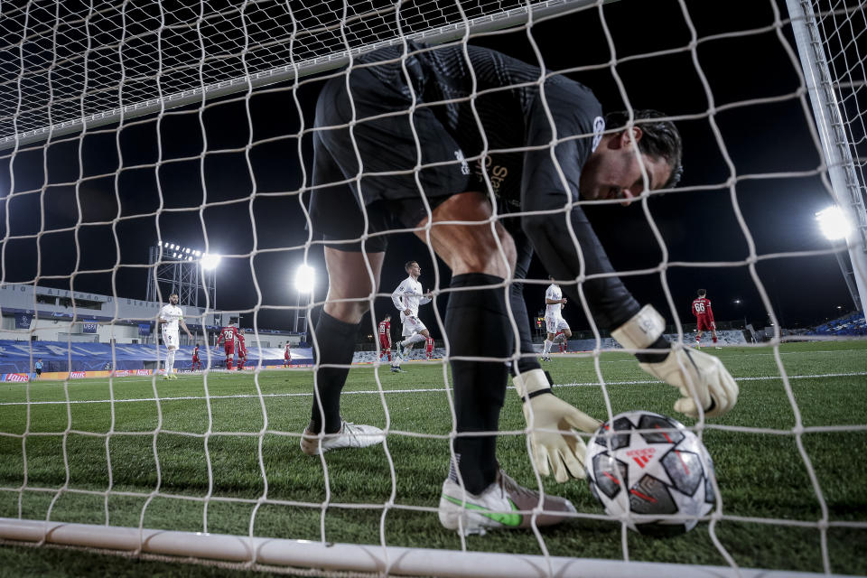 El arquero de Liverpool Alisson recoge el balón tras encajar un gol en el partido contra el Real Madrid por la ida de cuartos de final de la Liga de Campeones, el martes 6 de abril de 2021, en Madrid. (AP Foto/Manu Fernández)