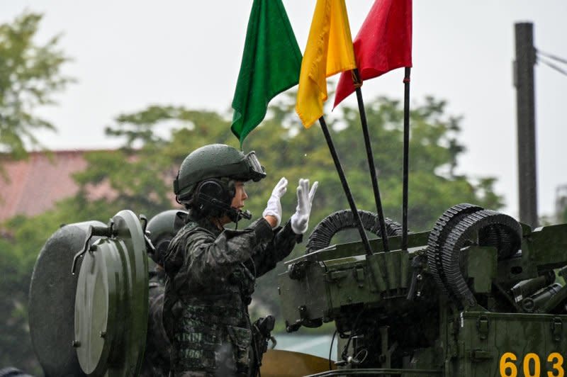 A soldier in an armored vehicle waves to spectators during a military parade in downtown Seoul, the first in ten years. Photo by Thomas Maresca/UPI