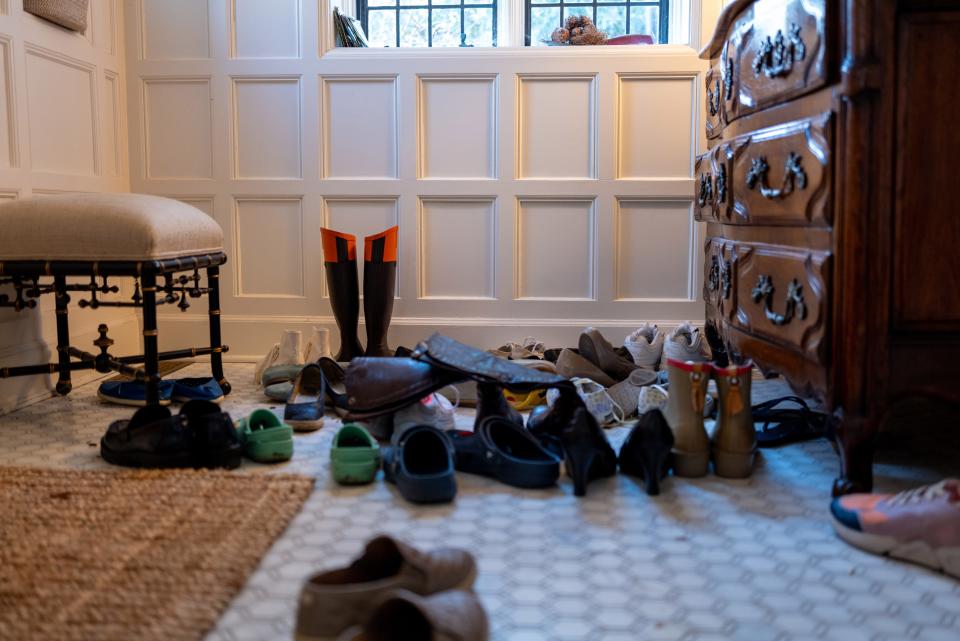 A large family's mudroom full of shoes.