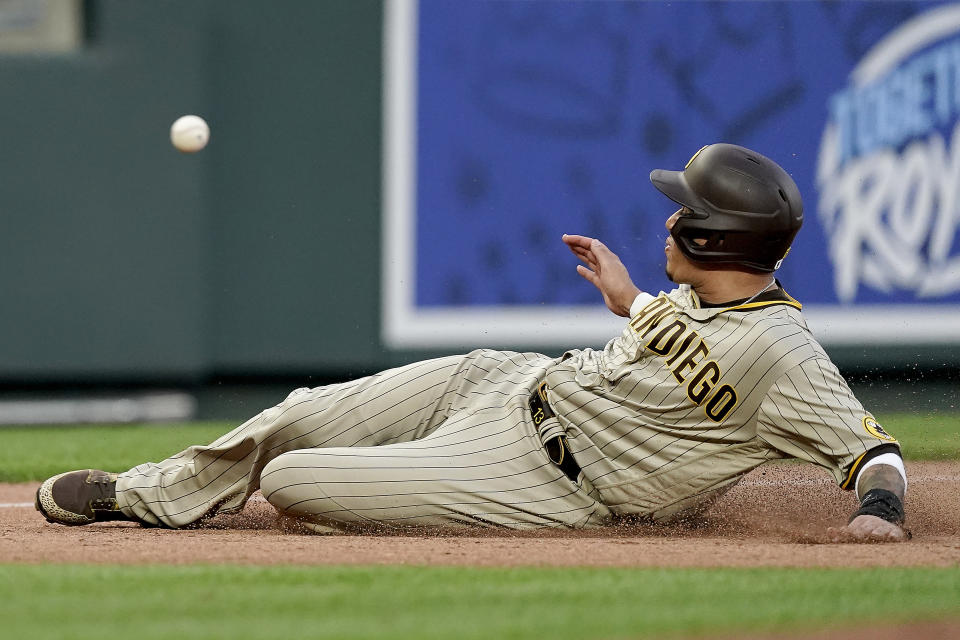 San Diego Padres' Manny Machado beats the tag to advance to third on an RBI single by Brandon Drury during the third inning of a baseball game against the Kansas City Royals Saturday, Aug. 27, 2022, in Kansas City, Mo. (AP Photo/Charlie Riedel)