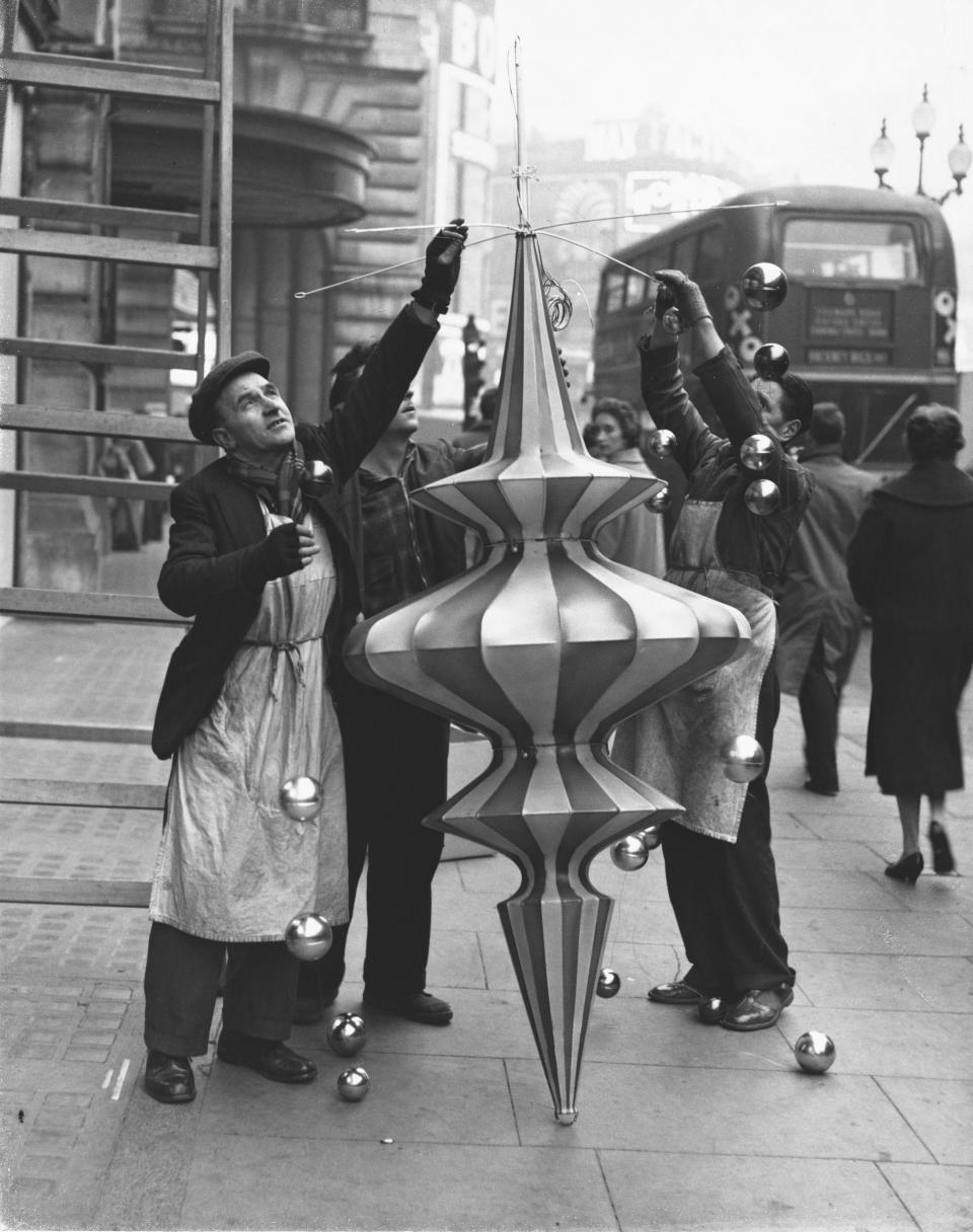 Men fasten globes to one of the large Christmas lanterns ready to be erected in Regent Street in London.&nbsp;