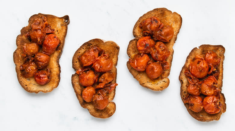 Four slices of toast with fried tomatoes
