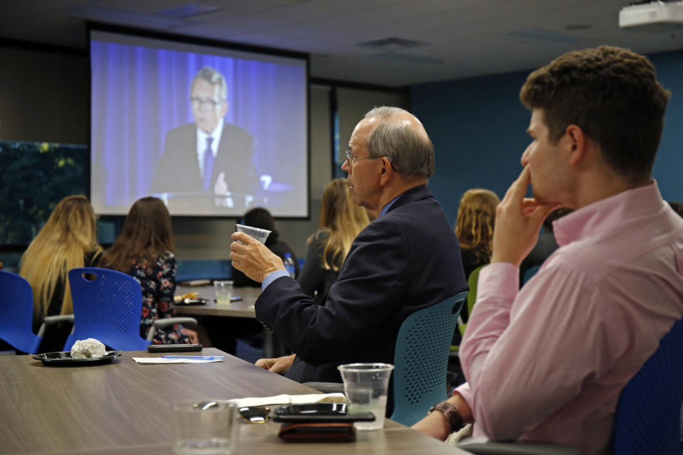 Former Ohio Gov. Bob Taft, center, joins students at a watch party for a debate between Ohio Attorney General and Republican gubernatorial candidate Mike DeWine, shown on screen, and Ohio Democratic gubernatorial candidate Richard Cordray at the University of Dayton, Wednesday, Sept. 19, 2018, in Dayton, Ohio. (AP Photo/Gary Landers)