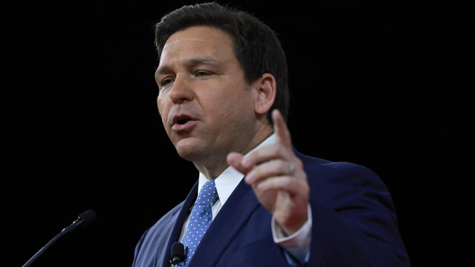 Florida Gov. Ron DeSantis stands at a microphone as he speaks at the Conservative Political Action Conference. 