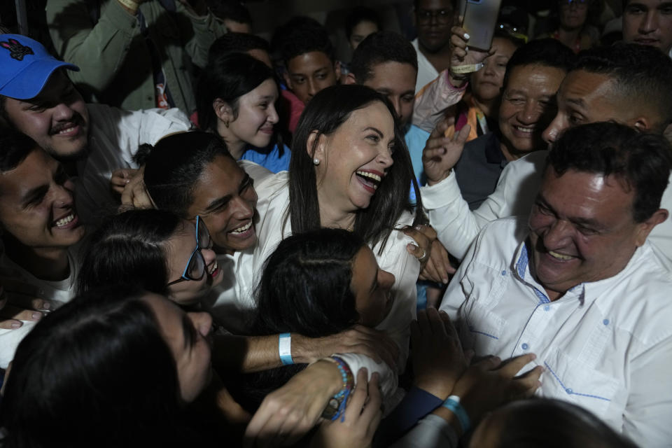 La aspirante opositora María Corina Machado, en el centro, festeja con sus seguidores después de escuchar los resultados que le daban como ganadora de las primarias de la oposición, en su sede de campaña en Caracas, Venezuela, el domingo 22 de octubre de 22, 2023. Machado corre para enfrentar en las presidenciales de 2024 a Nicolas Maduro. (AP Foto/Ariana Cubillos)