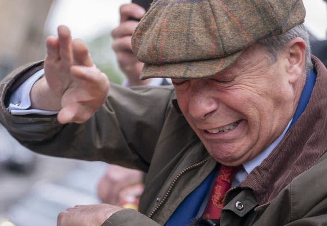 Reform UK leader Nigel Farage reacts after something is thrown towards him on the Reform UK campaign bus in Barnsley, South Yorkshire, whilst on the General Election campaign trail on June 11 