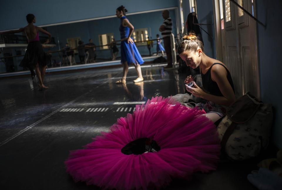 A dancer of the national ballet of Cuba prepares to rehearse a play in Havana, Cuba, Thursday, Dec. 12, 2019. The Soviet-style system that recruits children into a system of increasingly selective state dance schools has produced hundreds of elite dancers including Lorna Feijóo, Rolando Sarabia, Taras Domitro, Anette Delgado and Carlos Acosta. (AP Photo/Ramon Espinosa)