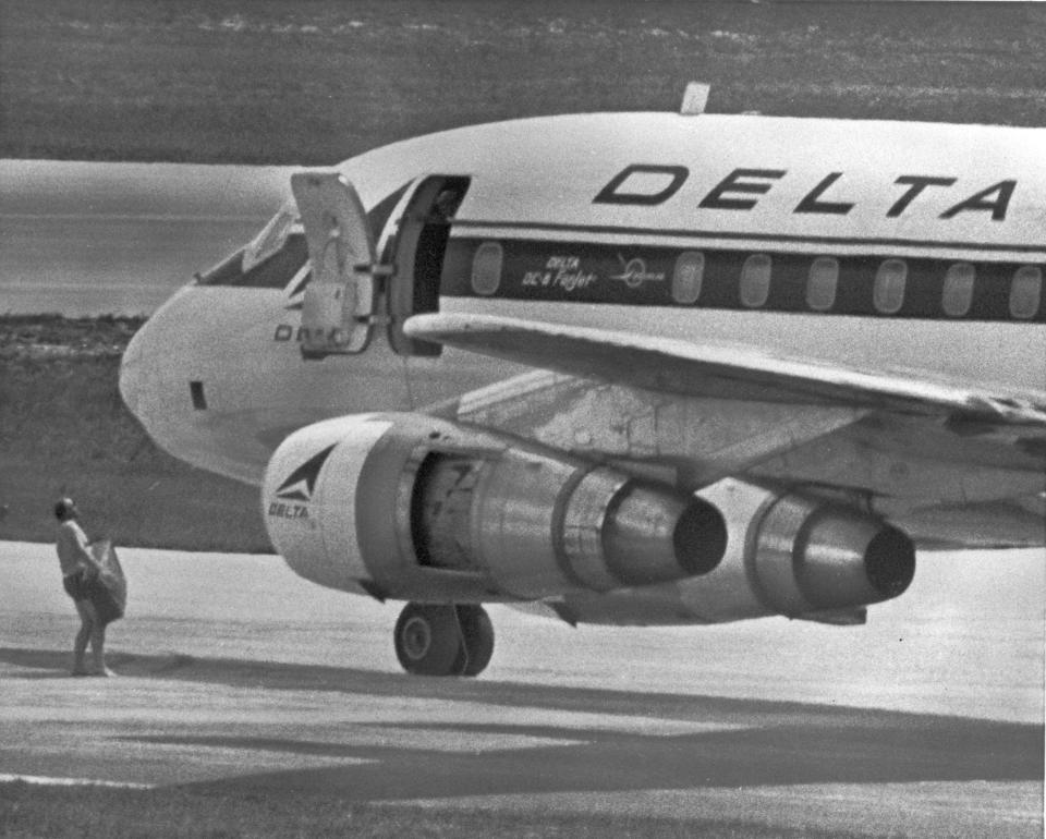 RIGHT: In this July 31, 1972 file photo, an FBI agent wearing only a pair of swim trunks carries a case containing a $1 million ransom to the opened door of a hijacked Delta Airlines jet in Miami. Melvin McNair and his associates demanded the ransom in exchange for freeing 86 people on board and passage to Algeria.