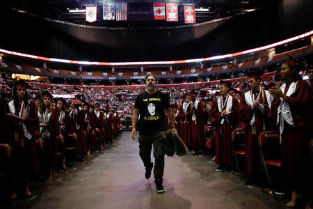 Manuel Oliver, father of Joaquin Oliver, one of the victims of the mass shooting at Marjory Stoneman Douglas High School, walks past his son's classmates, during their graduation ceremony in Sunrise, Florida, U.S., June 3, 2018. REUTERS/Carlos Garcia Rawlins