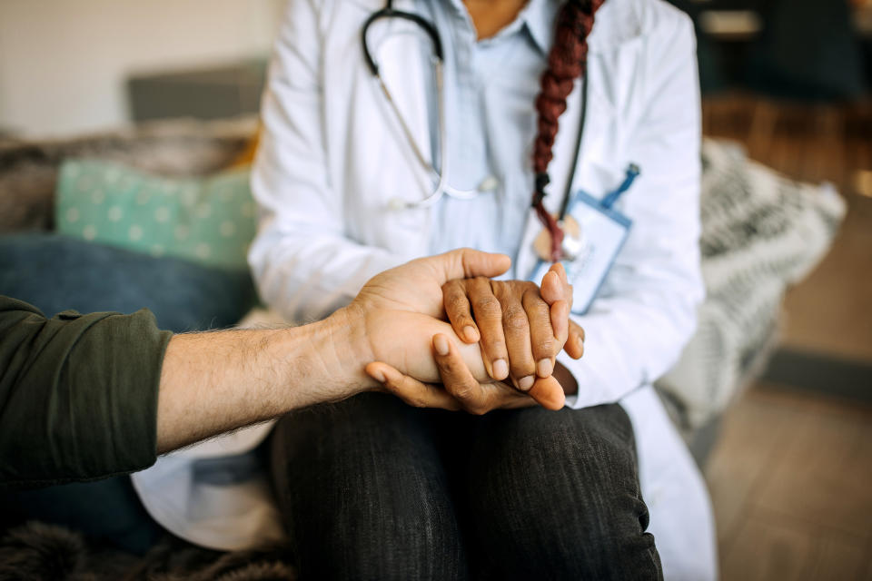 A female doctor consoles a senior patient