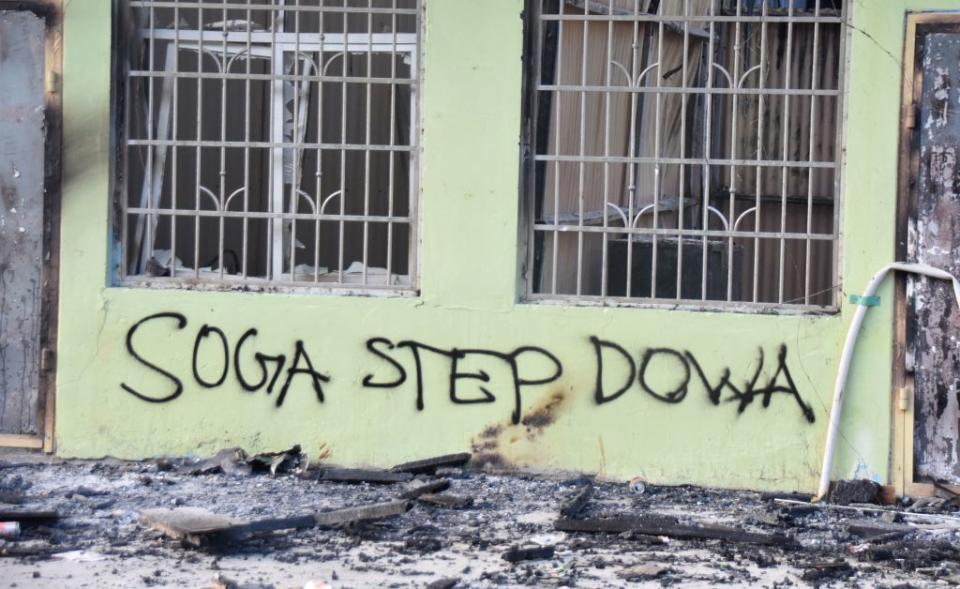 Anti-government messages seen on a burnt-out building in Honiara, Solomon Islands, on Nov. 27, 2021, as a tense calm returned after days of intense rioting.<span class="copyright">CHARLEY PIRINGI/AFP via Getty Images</span>