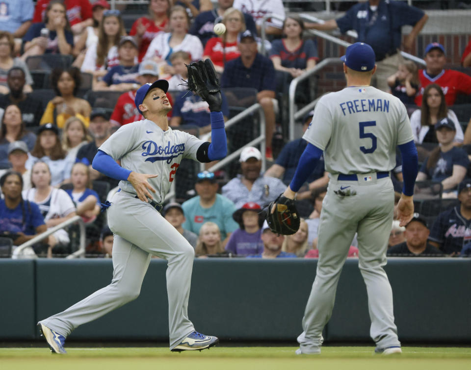 Los Angeles Dodgers right fielder Trayce Thompson makes an out against Atlanta Braves lead-off batter Dansby Swanson as Freddie Freeman (5) covers during the first inning of a baseball game Sunday, June 26, 2022, in Atlanta. (AP Photo/Bob Andres)