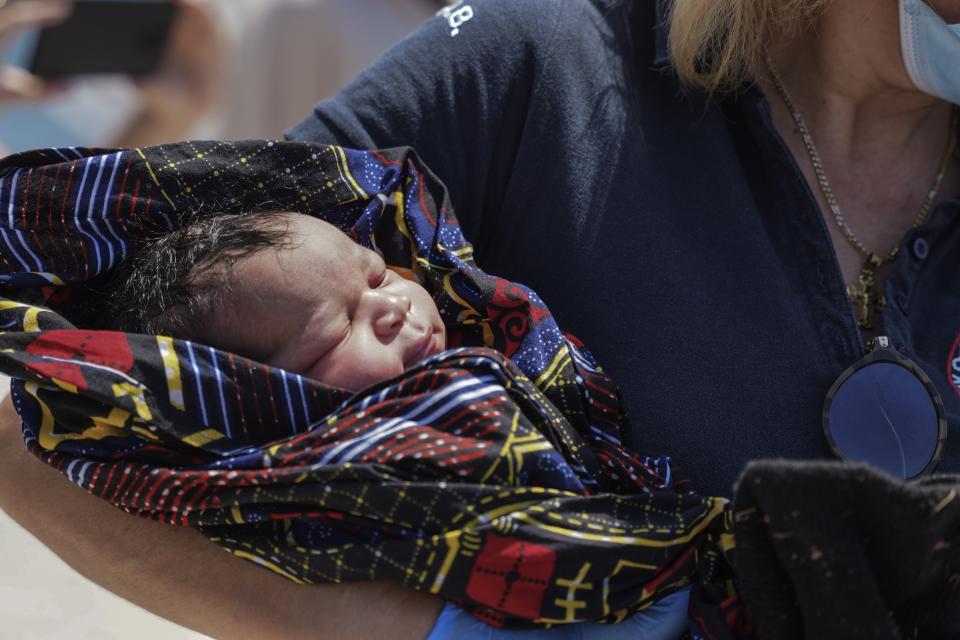 A paramedic holds a newborn boy at Mytilene port, on the northeastern Aegean Sea island of Lesbos, Greece, Wednesday, June 22, 2022. Authorities in Greece say a woman from Eritrea has given birth on an uninhabited rocky islet after traveling from nearby Turkey with other migrants. A coast guard official said 30 adult Eritreans ‒ 25 men and five women ‒ were spotted during a patrol near Lesbos. (AP Photo/Panagiotis Balaskas)