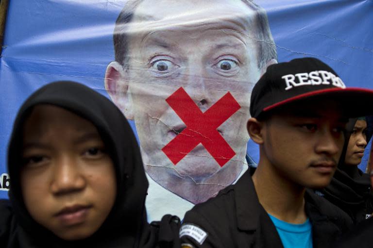 Indonesians rally in front of a vandalised portrait of Australian Prime Minister Tony Abbott during a protest outside the Australian embassy in Jakarta on March 10, 2015