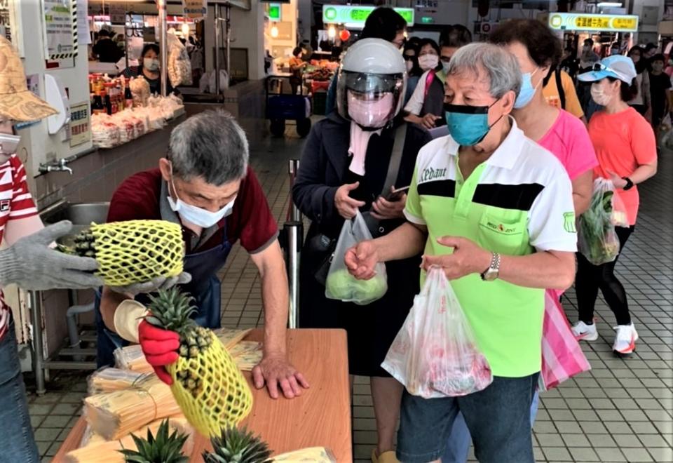 台南市政府經發局在傳統市場舉辦「快閃」促銷送鳳梨活動，民眾反應熱烈。（經發局提供）