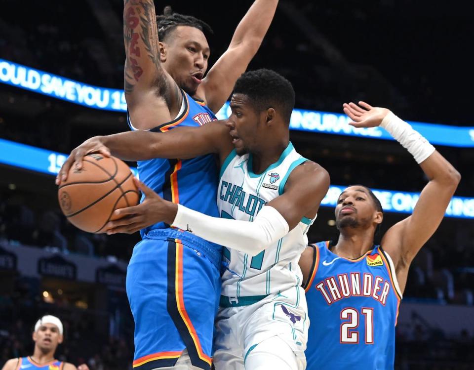 Charlotte Hornets forward Brandon Miller, center, passes the ball to a teammate around an Oklahoma City Thunder defender during first half action on Sunday, October 15, 2023 at Spectrum Center in Charlotte, NC.
