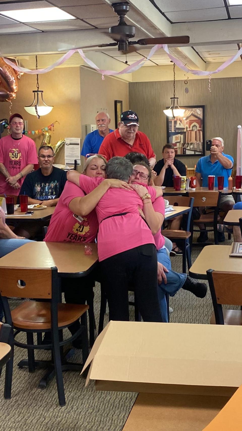 Skyline Chili waitress Wilma Mounce Popp ("Ms. Wilma) hugs her fellow employees while celebrating her 50th anniversary at the restaurant's Covington location.