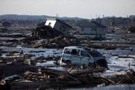 Debris and cars sit in a former rice field flooded by the tsunami and slowly drained using mechanical pumps in Higashimatsushima, Miyagi prefecture. Workers at Japan's crippled nuclear plant Sunday struggled to stop a radioactive water leak into the Pacific, as the government warned the facility may spread contamination for months