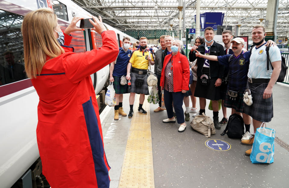 Scotland fans have their picture taken with and LNER staff member at Edinburgh Waverley railway station as they prepare to travel to London ahead of the UEFA Euro 2020 match between England and Scotland at Wembley Stadium. Issue date: Friday June 18, 2021. (Photo by Jane Barlow/PA Images via Getty Images)