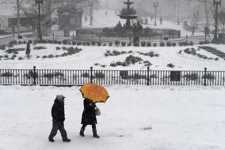 People walk in the Borough Hall section of downtown Brooklyn in New York City in falling snow, January 26, 2015. REUTERS/Stephanie Keith