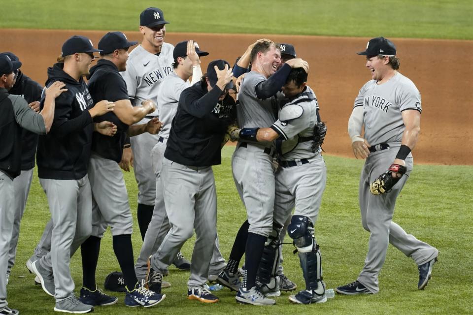 ARCHIVO - El abridor de los Yanquis de Nueva York Corey Kluber (tercer desde la derecha) celebra junto al receptor Kyle Higashioka (segundo desde la derecha), y el resto del equipo luego de lanzar un juego sin hit ante los Rangers de Texas, en el juego de béisbol en Arlington, Texas, el miércoles 19 de mayo de 2021. (AP Foto/Tony Gutierrez, Archivo)