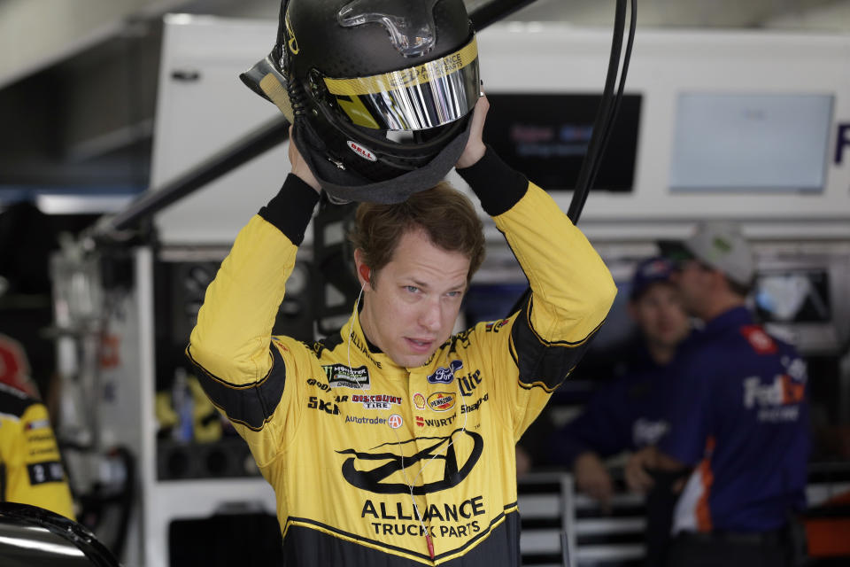 Brad Keselowski puts on his helmet during practice for Sunday's NASCAR Cup Series auto race at Charlotte Motor Speedway in Concord, N.C., Saturday, Sept. 28, 2019. (AP Photo/Gerry Broome)