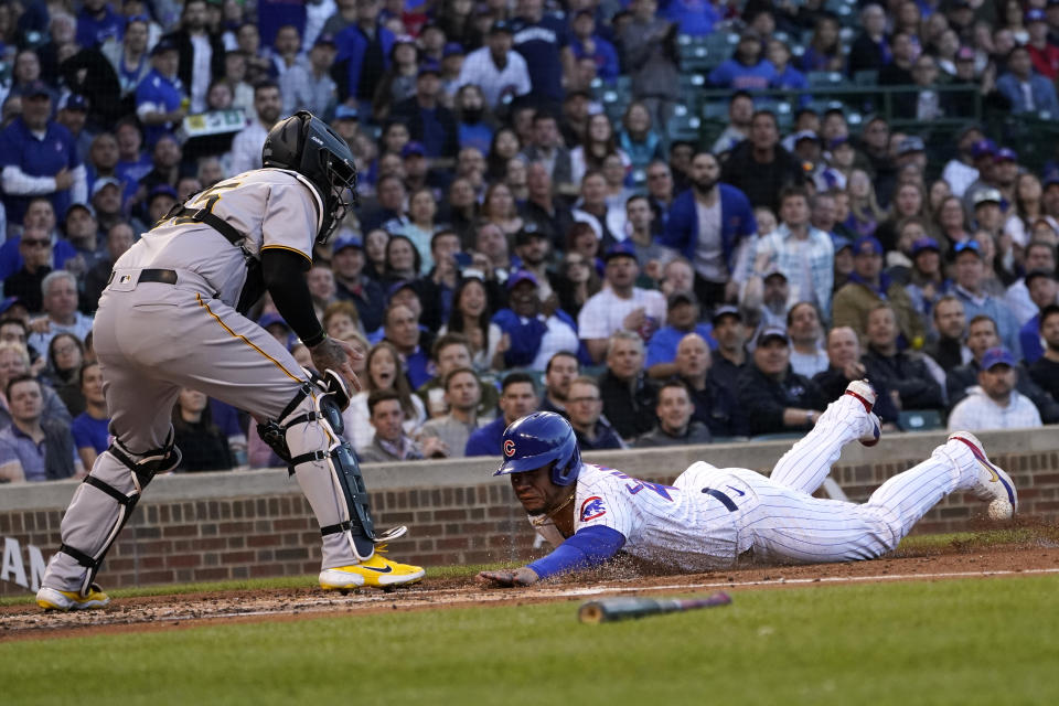 Chicago Cubs' Willson Contreras scores on a sacrifice fly by Jonathan Villar, as Pittsburgh Pirates catcher Roberto Perez waits for the throw during the first inning of a baseball game Thursday, April 21, 2022, in Chicago. (AP Photo/Charles Rex Arbogast)