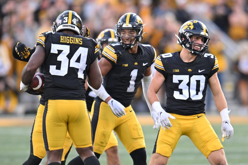 October 7, 2023;  Iowa City, Iowa, USA;  Iowa Hawkeyes linebacker Jay Higgins (34) and defensive back Xavier Nwankpa (1) and defensive back Quinn Schulte (30) react after a Higgins interception against the Purdue Boilermakers during the fourth quarter at Kinnick Stadium.  Mandatory Credit: Jeffrey Becker-USA TODAY Sports