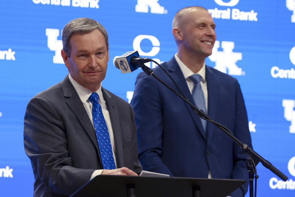 Kentucky Athletic Director Mitch Barhart, left, introduces new Kentucky mens' basketball head coach Mark Pope, right, during a press conference in Lexington, Ky., Sunday, April 14, 2024. (AP Photo/James Crisp)