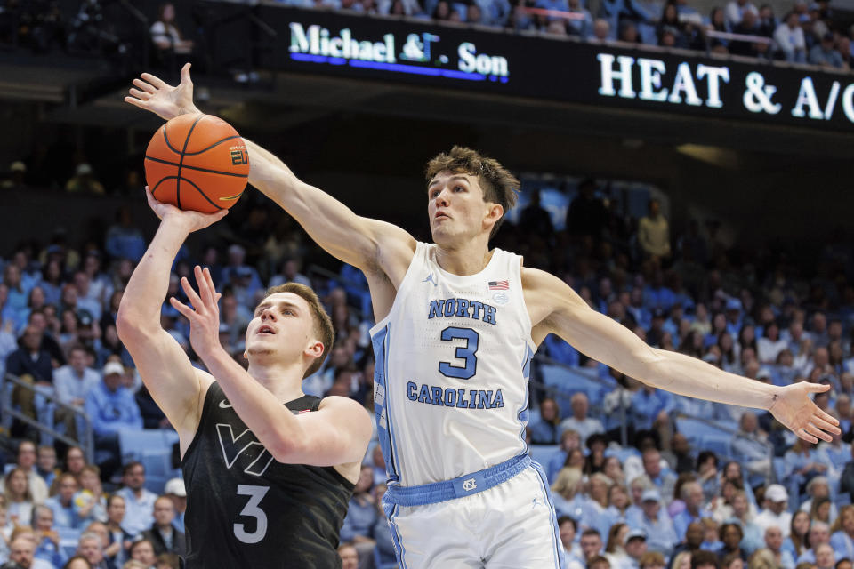 North Carolina's Cormac Ryan, right, blocks the shot of Virginia Tech's Sean Pedulla, left, during the second half of an NCAA college basketball game in Chapel Hill, N.C., Saturday, Feb. 17, 2024. (AP Photo/Ben McKeown)